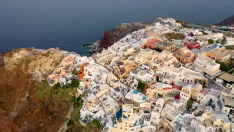 Increíble-Video-Del-Famoso-Pueblo-Pintoresco-Blanco-Y-Colorido-De-Oia-Construido-Sobre-Un-Acantilado-Al-Atardecer,-Isla-De-Santorini,-Cícladas,-Grecia