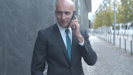 business team standing at office building outside, using tablet, laptop and mobile phone