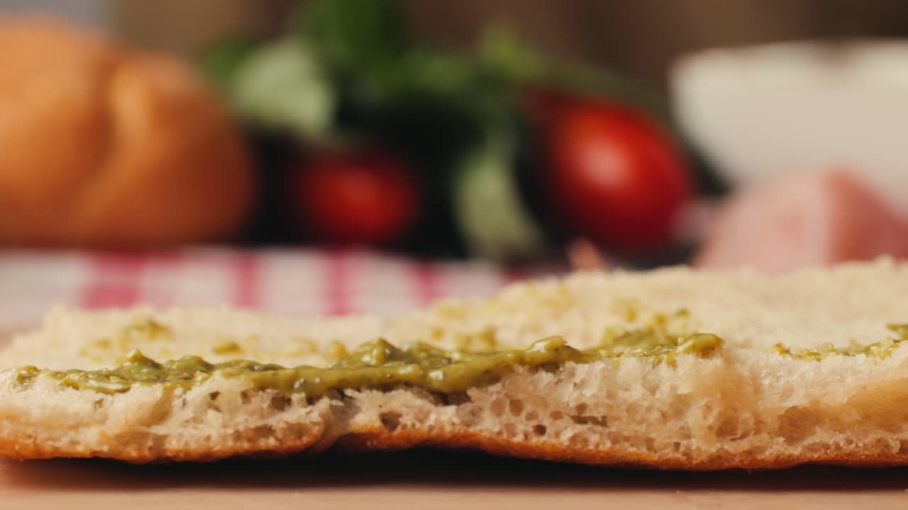 Mortadella ham sandwich, Traditional italian focaccia filled with thin pesto slices of mortadella, served by chef man in cafe restaurant. Macro of traditional italian spanish tapas antipasti.