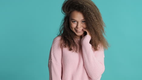 Caucasian-curly-haired-woman-smiling-to-the-camera.