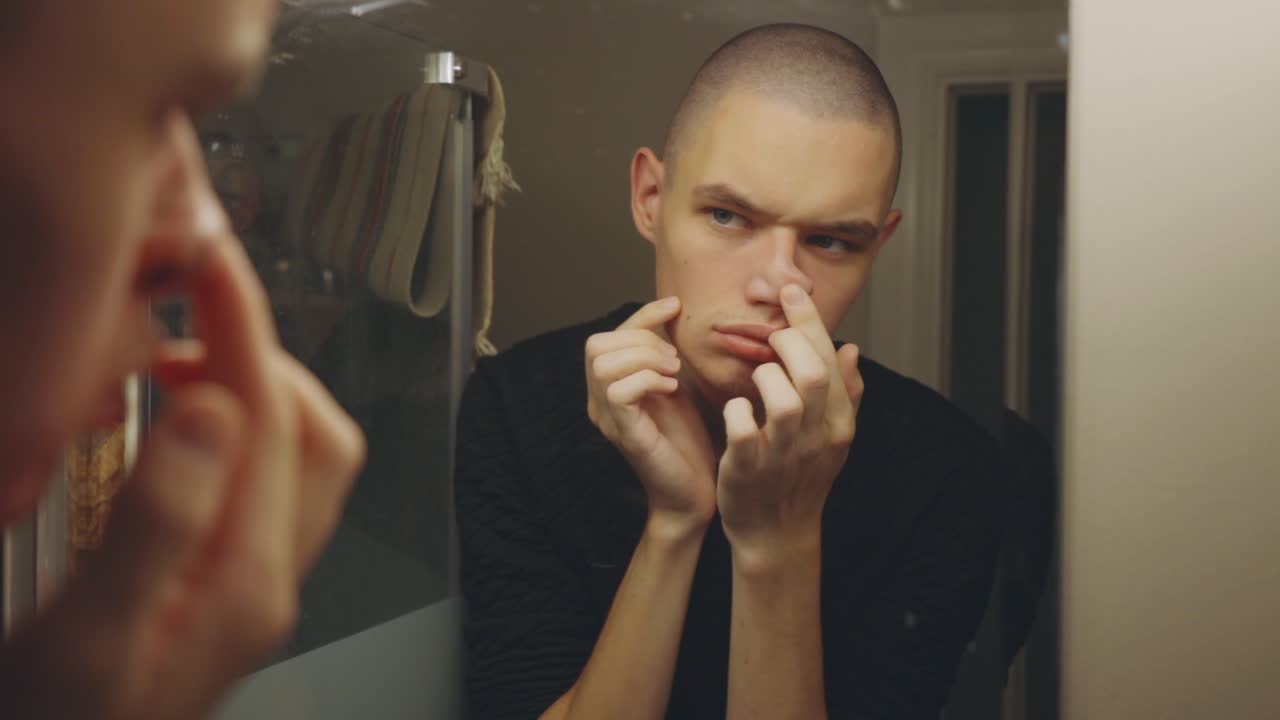 Young Man Making Funny Face Effects With His Fingers Upon Looking At The Mirror - Closeup Shot