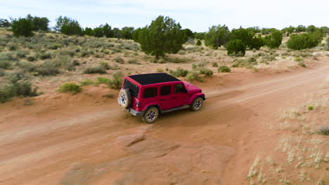 red jeep wrangler driving on off-road trail to white pocket in utah, arizona