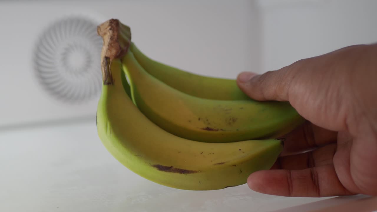 Bunch of Green Bananas in Hand