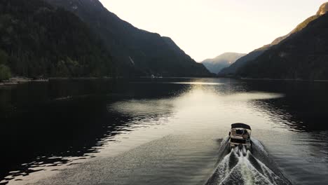 aerial drone shot following boat in indian arm, an ocean in vancouver, canada