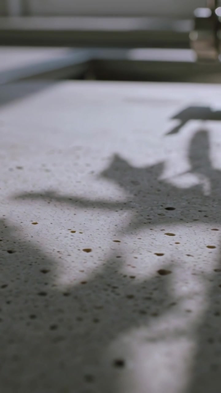 Vertical video: Shifting kitchen sun casting leaf shadows across speckled top by faucet, copy space