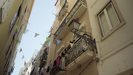 lisbon old street with balcony and ancient street lamp at sunshine