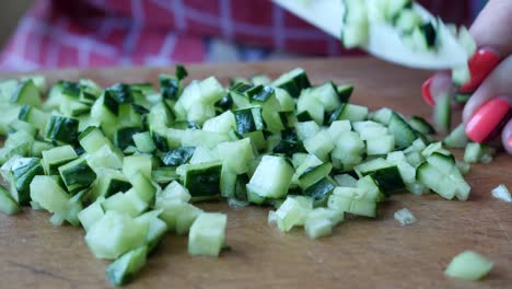 small slices of juicy green and ripe cucumber on wooden kitchen board