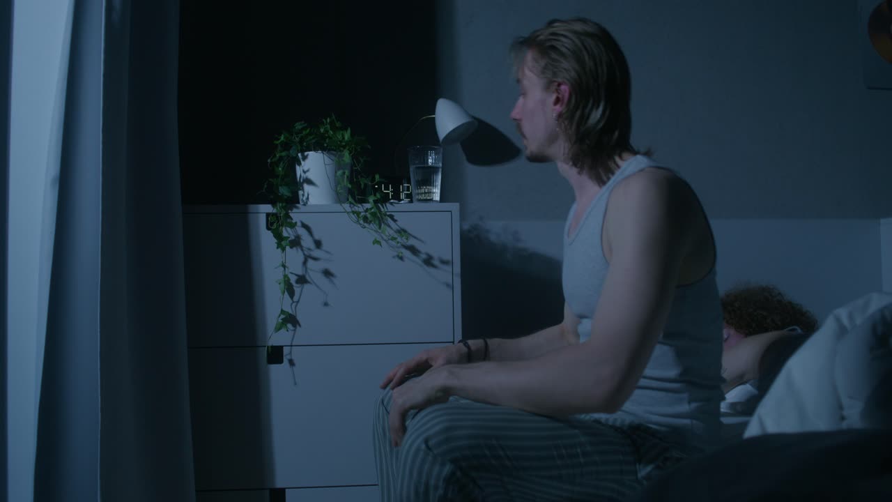 Man drinking water in bed at night