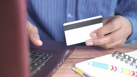 person using a credit card on a laptop