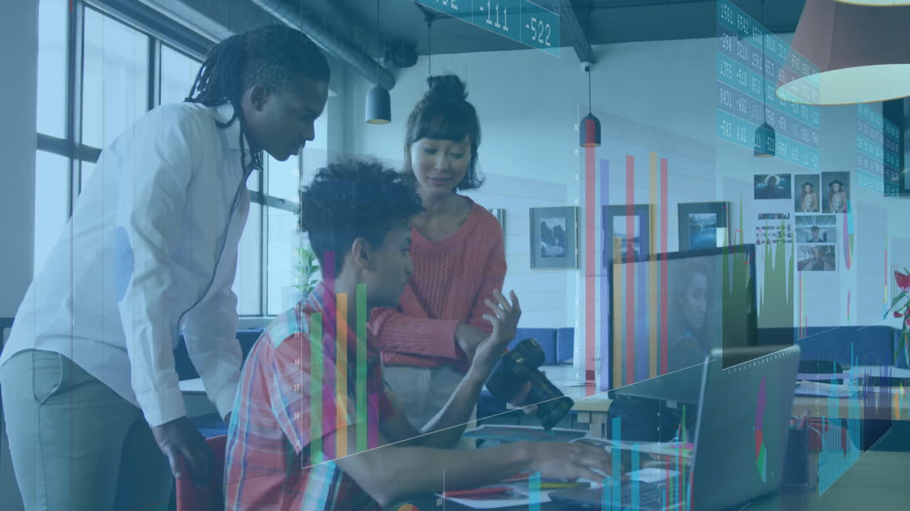 Three coworkers collaborating around desk in tech office showing animated charts and camera icons