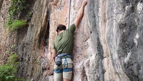 climber ascending a rocky cliff in krabi