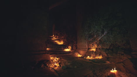 Mysterious underground chamber illuminated by candles in dark environment