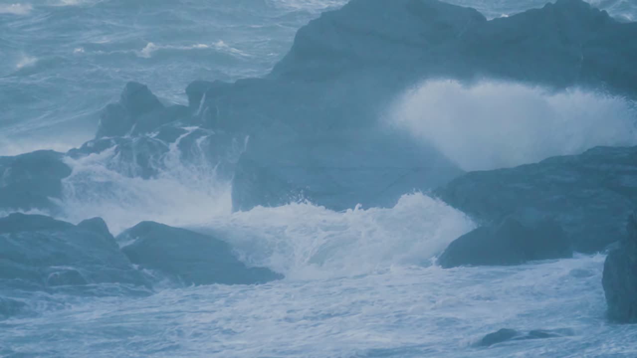 바다의 파도가 바위 위에 부히고 폭풍우가 불고 있는 날씨에 초속 느린 동작으로 강한 바람이 불고 있는 폭풍우, 강력한 격동적인 파도, 진정시키는 매혹적인 진정시키는 배경 4k.