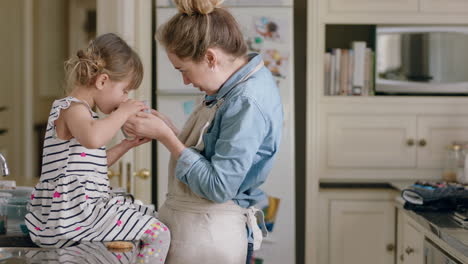 mother and daughter drinking hot chocolate together in kitchen happy mom caring for little girl enjoying homemade delicious beverage at home