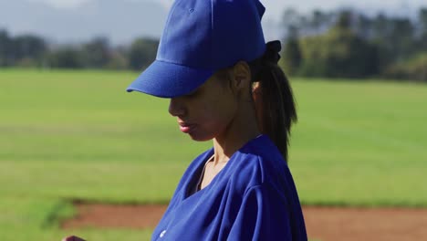 Retrato-De-Feliz-Jugadora-De-Béisbol-De-Raza-Mixta,-En-El-Campo-Sonriendo