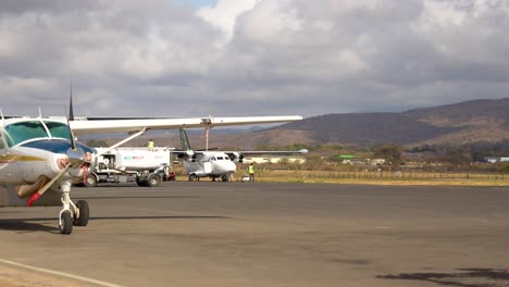 chargement des bagages sur un avion à turbopropulseur dans la piste près de la base du mont kilimandjaro, prise de vue large