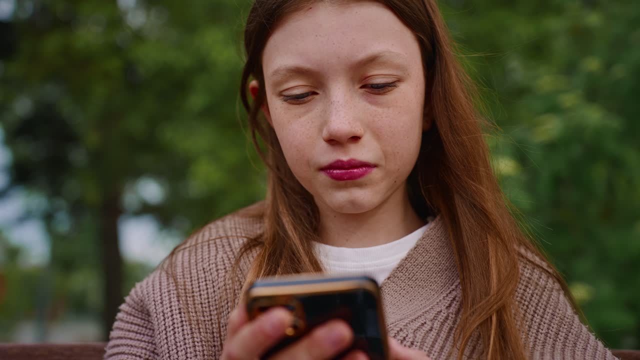 밖에서 스마트폰을 사용하는 십대 소녀