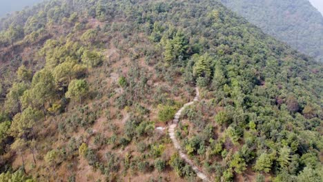 flying above a trail on a mountain ridge on a very hazy autumn day