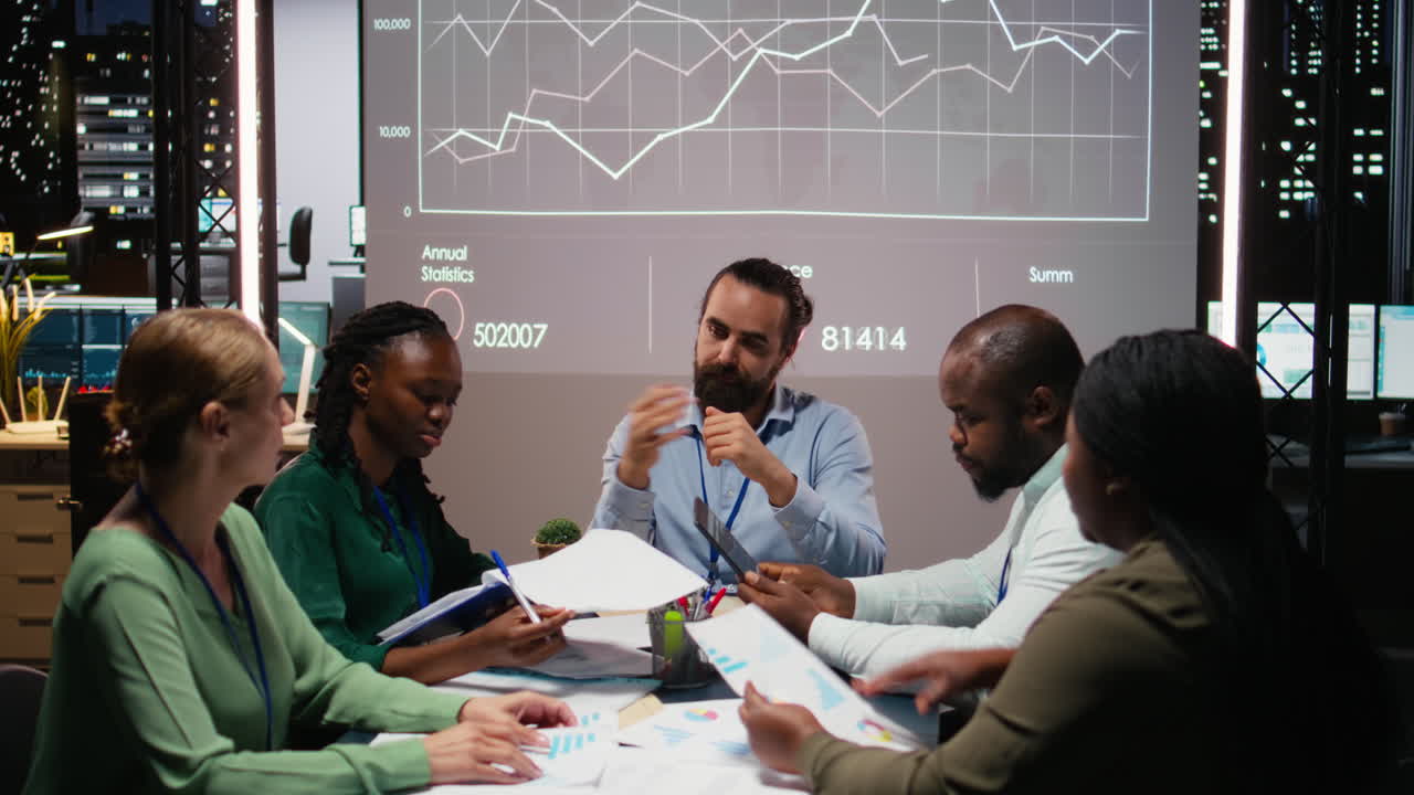 Business people prepare for a pitch by studying financial data on files reports