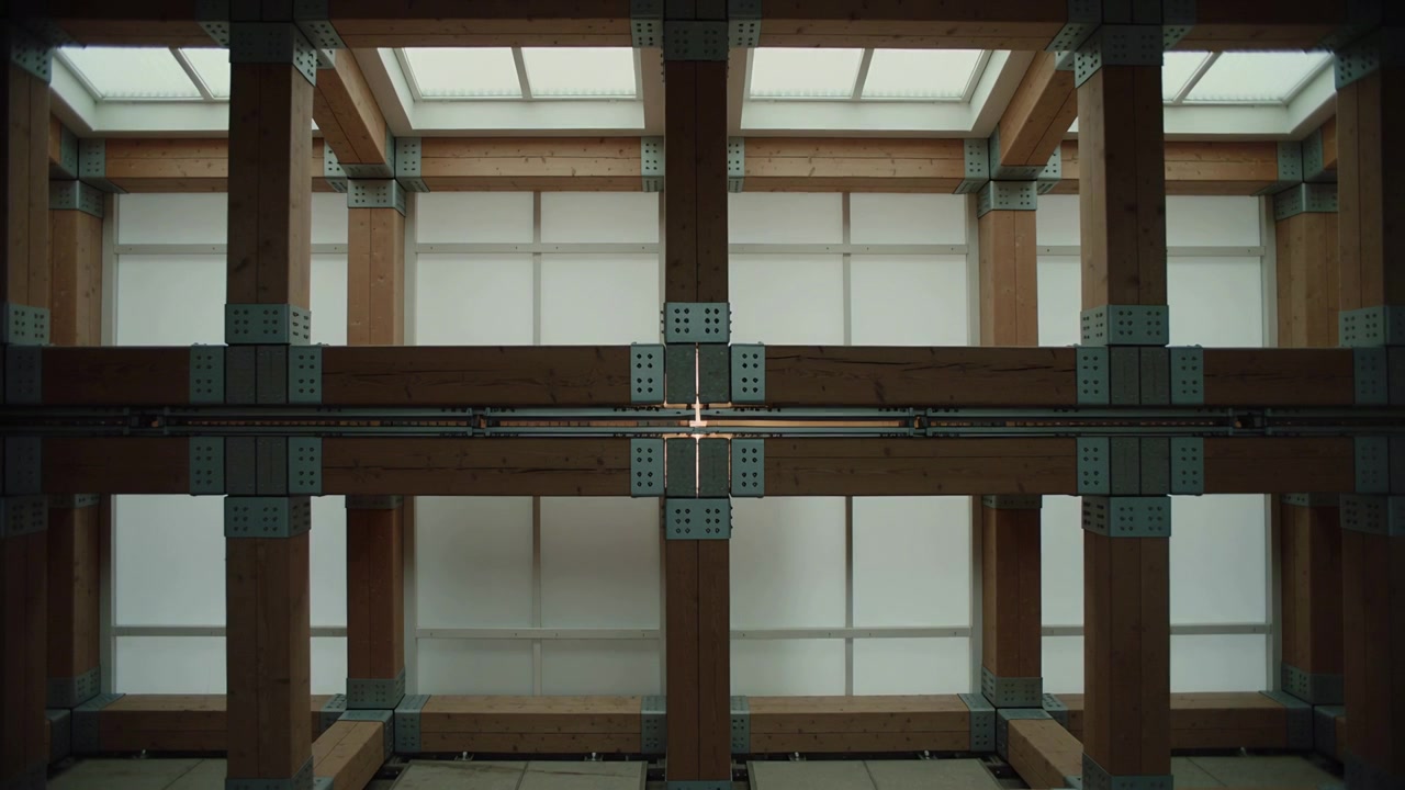 Catching skylight, centered timber frame with metal plates creating bright glint on rail in atrium
