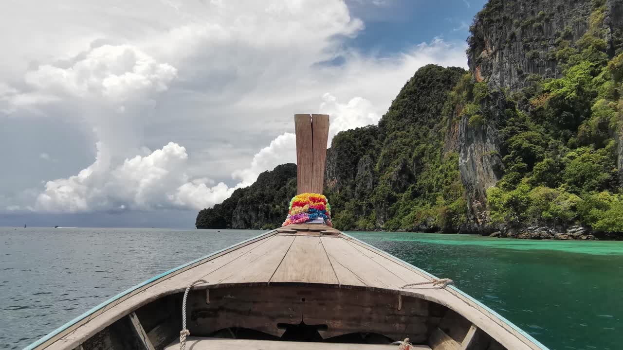 Longtail Boat Journey with a Bow View, Revealing Thailand's Enchanting Rocky Cliffs near Ko Phi Phi Island
