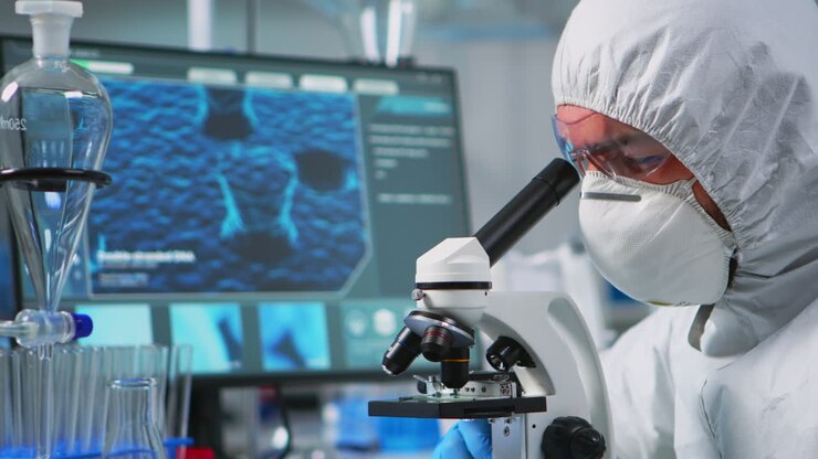 Close up of man scientist looking through a microscope