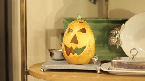 cabeza de calabaza en vidrio como decoración de mesa casera, celebración de halloween