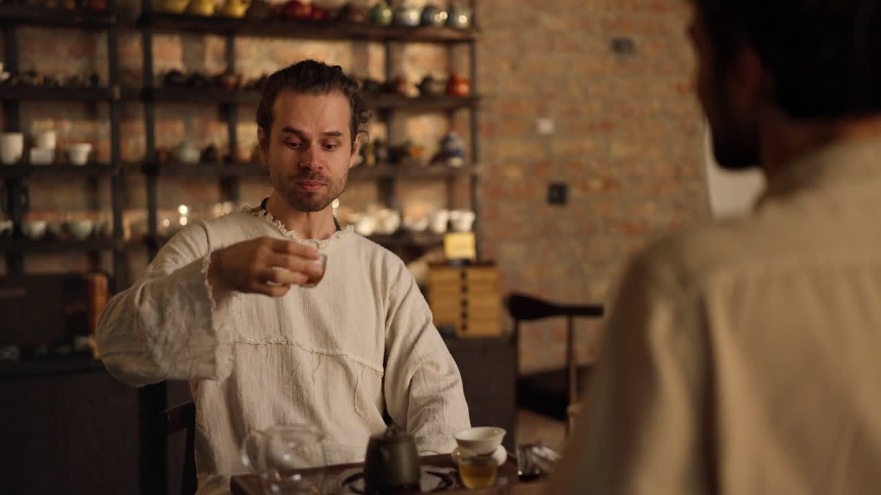 dos hombres disfrutando de una ceremonia tradicional de té en una tienda de té