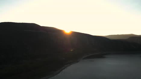 Drone-Volando-Sobre-La-Montaña-Para-Revelar-El-Sol-Poniente,-Vail-Lake-Temecula