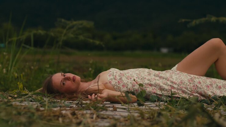 Woman Relaxing in a Field at Sunset