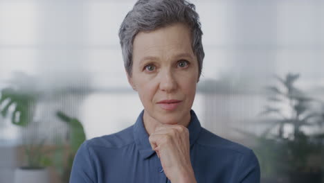 portrait professional senior business woman looking pensive at camera contemplative middle aged entrepreneur thinking in office background slow motion