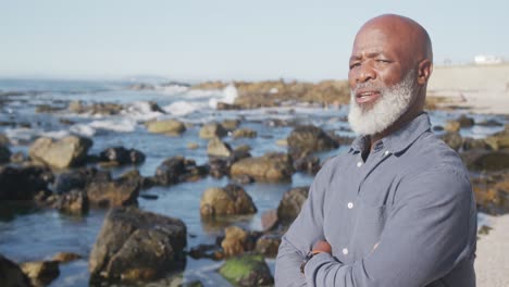 portrait of happy senior african american man at beach, copy space, slow motion