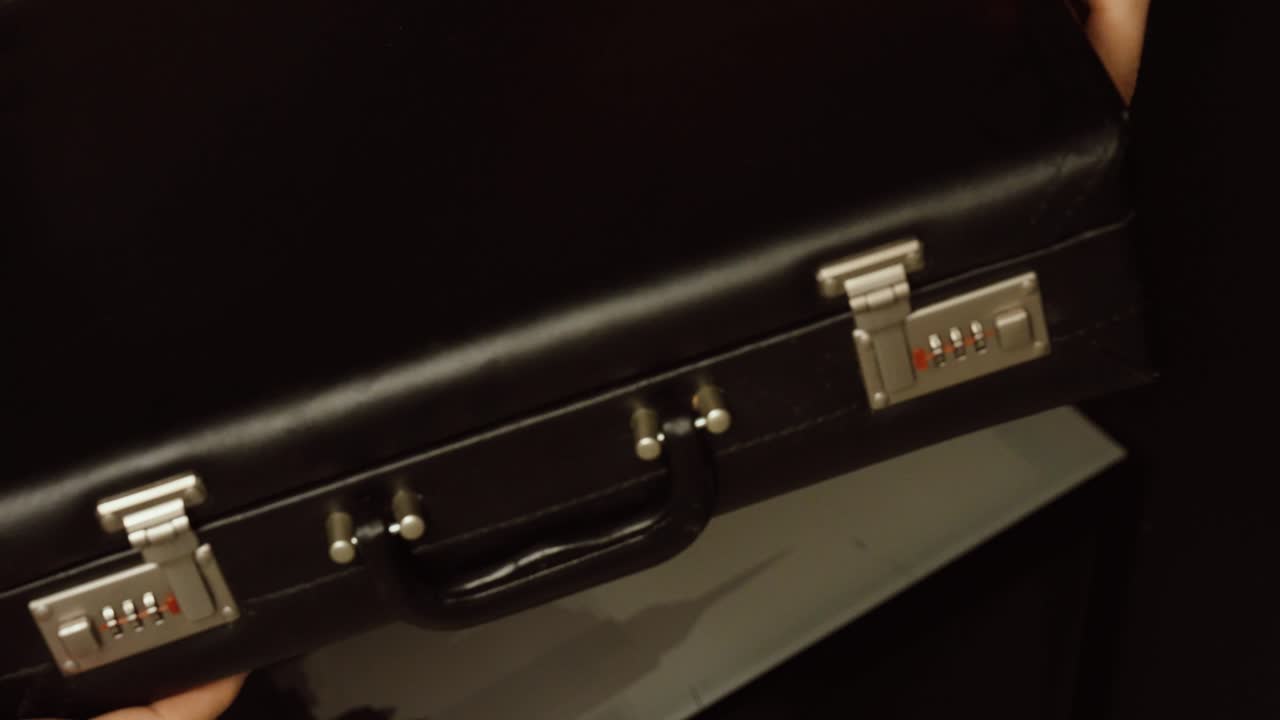 Close-up of a briefcase filled with stacks of banknotes being opened and closed. Concept of wealth, large amounts of cash, business deals, corruption, crime money, and financial power
