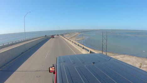 vista superior del techo del vehículo mientras se conduce en la calzada conmemorativa de kennedy sobre laguna madre a la isla barrera del padre norte cerca de corpus christi, texas, ee.uu.