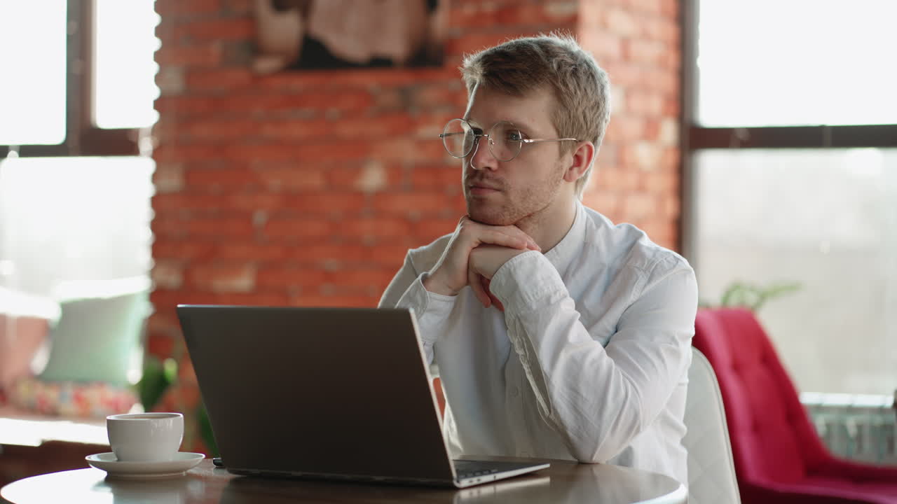 escritor o arquitecto está trabajando remotamente sentado en una cafetería con una computadora portátil y pensando retrato de especialista independiente