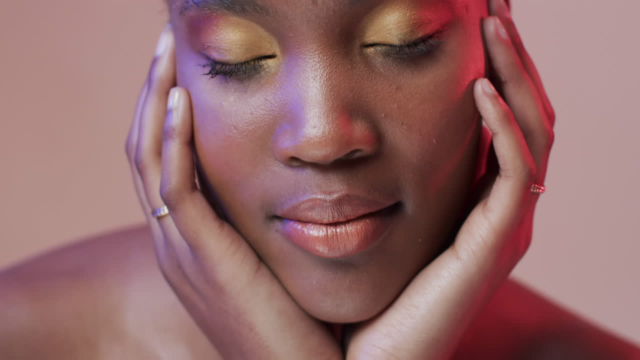 African american woman with short dark hair in blue and pink light, slow motion