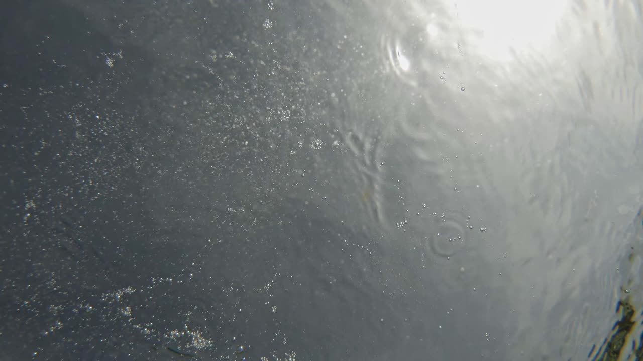 Rock Thrown And Submerge In Deep Clear Water On Sunny Day. Close Up