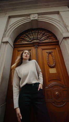 woman in fashionable outfit in front of an old building door
