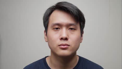 portrait of asian young man removing fashion elegant sunglasses, facing the camera