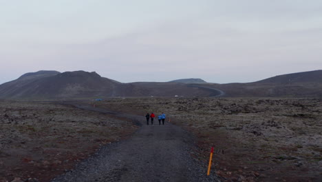 Vista-De-Pájaro-Drone-Vista-Cuatro-Personas-Caminando-Sendero-Aislado-En-Las-Tierras-Altas-De-Islandia.-Vista-Aérea-Grupo-De-Excursionistas-Trekking-En-La-Salvaje-Campiña-Nórdica-Islandesa