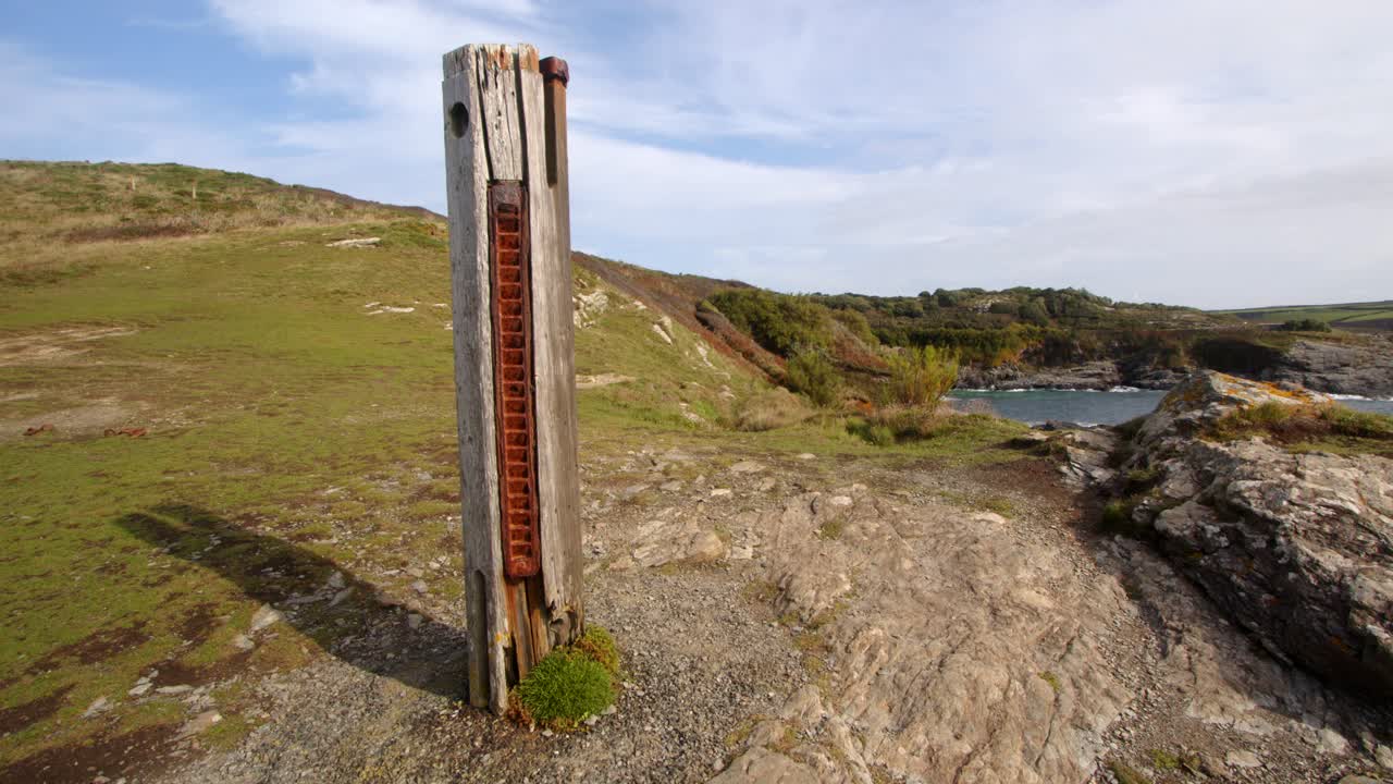 Wide shot of HMS Warspite monument with Bessy's Cove,The Enys in background