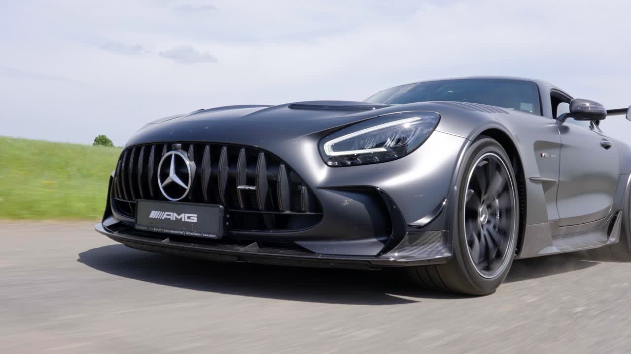 Close-Up of Sleek Black Sports Car in Motion on a Road Mercedes Benz