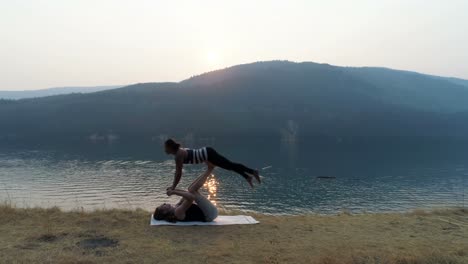 mujeres practicando acroyoga cerca del lago 4k