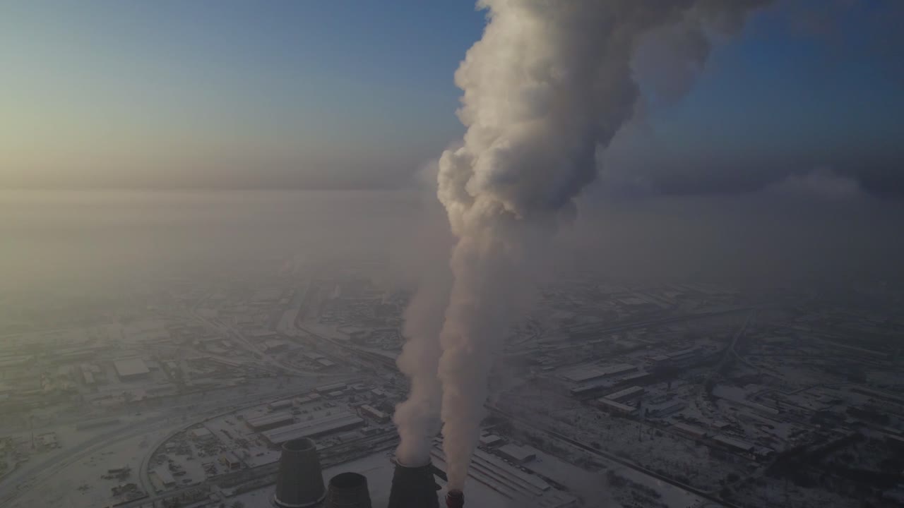 Industrial Power Plant in Snowy Landscape with Smoke Emission