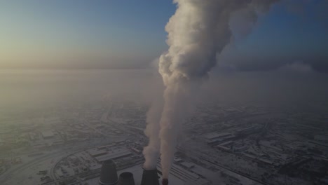 industrial power plant in snowy landscape with smoke emission