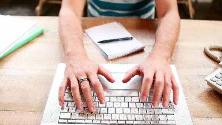 Man typing on laptop at desk, causing animated green avatar links growing tech network for work