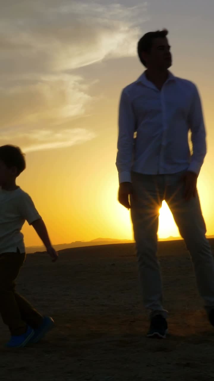 Sunset silhouettes of father and son