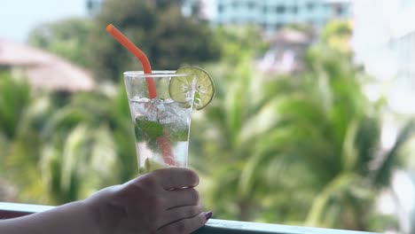 lady holds glass in hand and leans forward to taste beverage