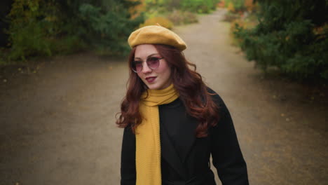 elegant lady with a yellow beret and muffler tilts her head left and right, attentively observing her surroundings while strolling in a vibrant garden