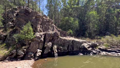 rocky cliffside and forest pool in nature